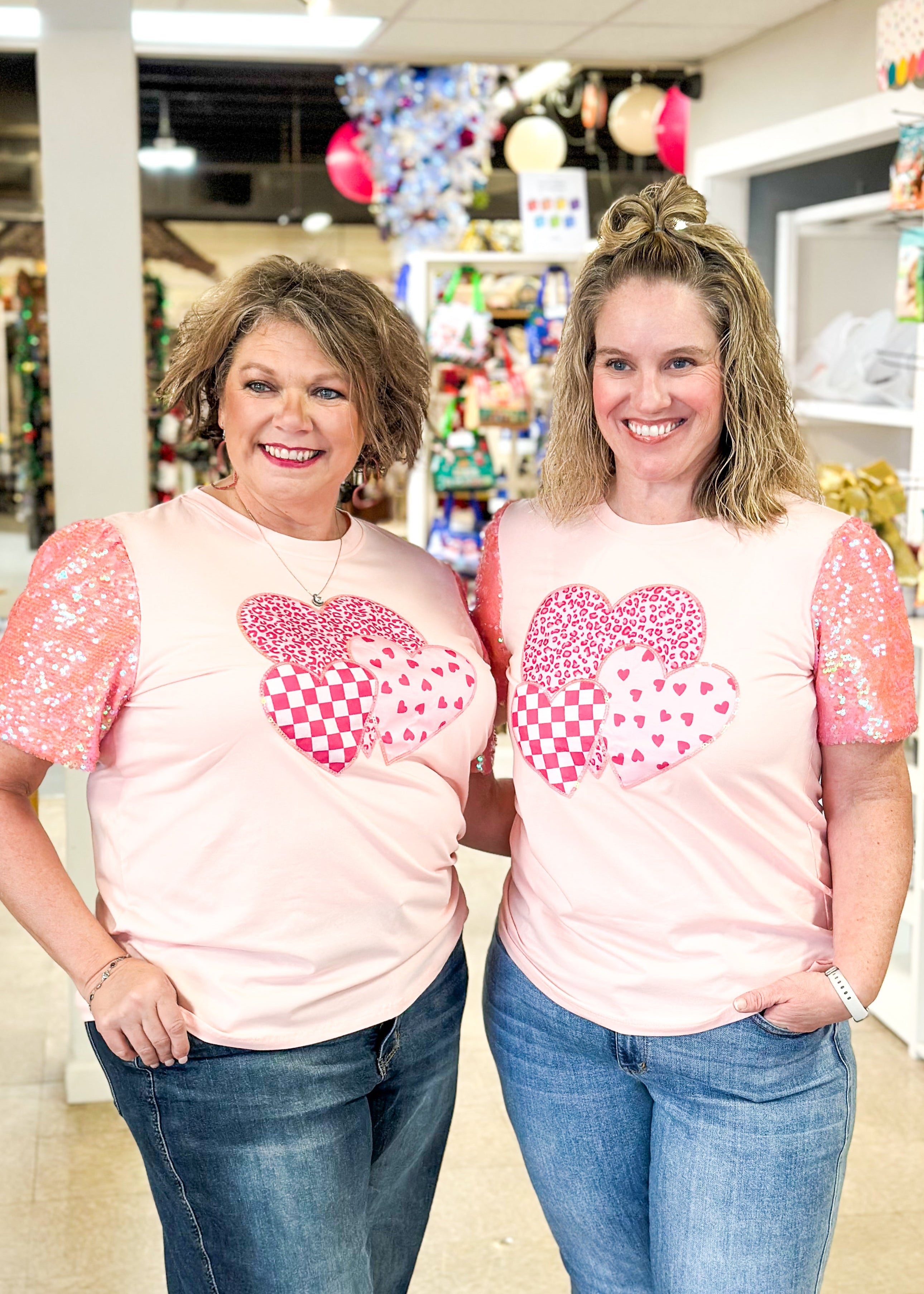 pink short sequin sleeve top with 3 hearts on the front outlined in sequins