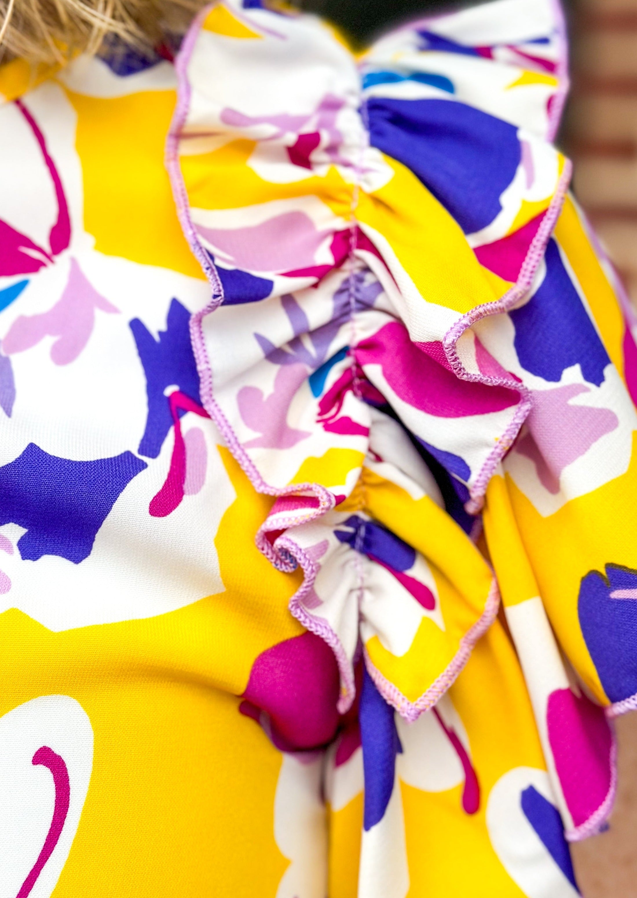 Purple and pink flowers on a yellow top with double ruffle sleeve