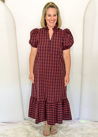 woman wearing a plaid midi dress with puff sleeves and a tiered ruffle hem