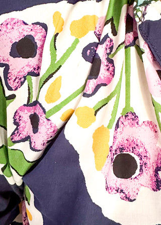 close up of women’s floral blouse in navy with contrast neckline detail, and decorative hem