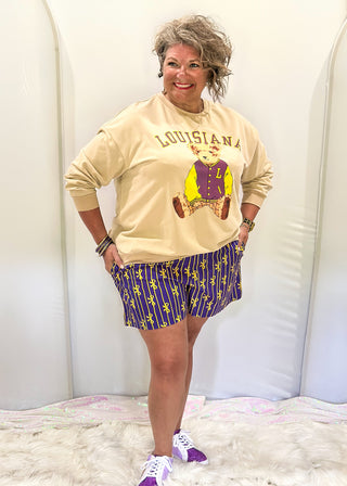 Purple boxer shorts with pockets. Gold stripe pattern with bows throughout. Elastic waist. 