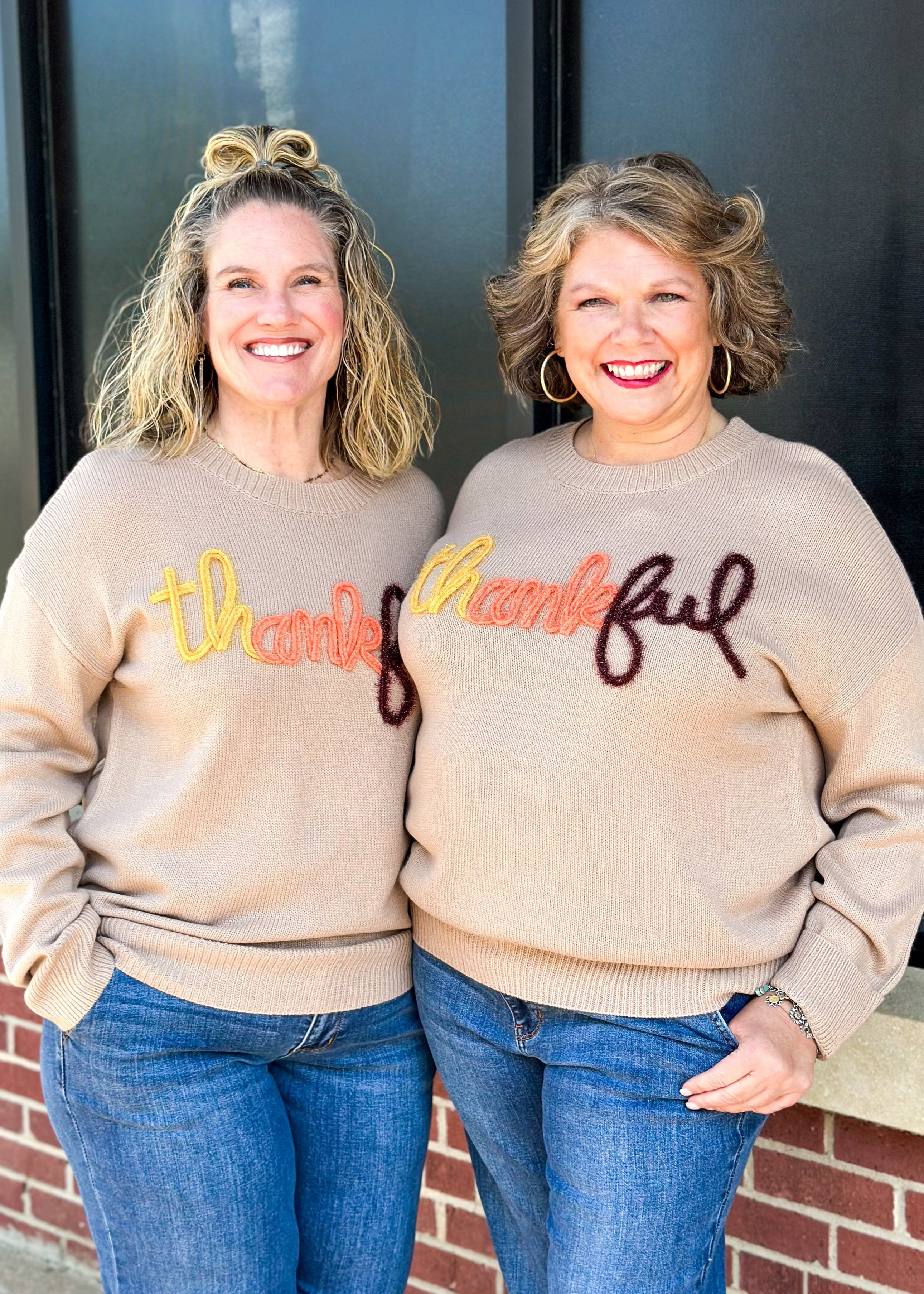 khaki long sleeve sweater with tinsel spelling out thankful across the front in yellow, orange and brown