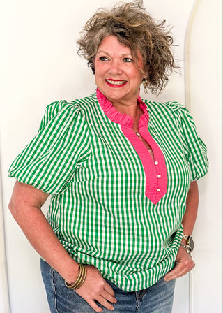 Women’s gingham blouse with decorative buttons and statement neckline detail.