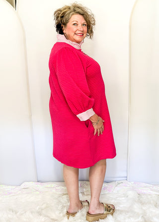 Hot pink quilted dress with striped collar and three-quarter sleeves.