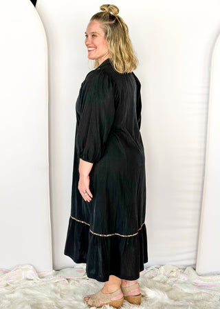 Black V-neck midi dress with leopard print detail on front and around bottom tier. 