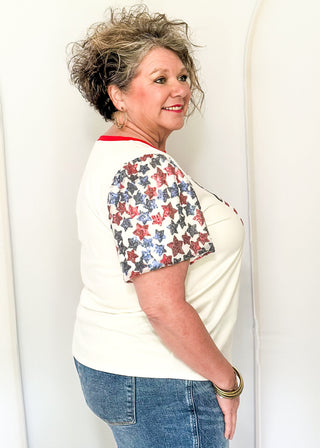 Sequin Flag with red and blue sequin star sleeves and red contrast banding on collar. 