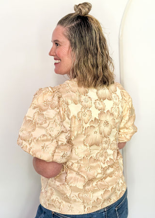 woman in jacquard floral puff sleeve top in champagne.