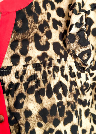 long sleeve leopard print top with red trim v-neck and buttons down the v; ruffle on shoulder 