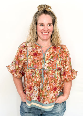 Fall floral Babydoll top with 3/4 puff sleeve, cream and blue strip detail on banding of hem and sleeve. blue ribbon detail on the front and tie at the collar. 