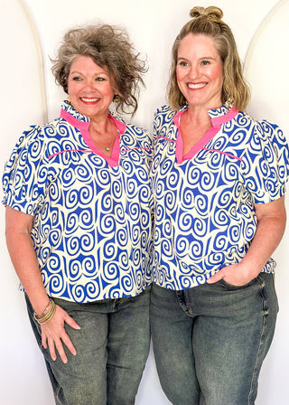 Royal blue swirl print top featuring pink contrast trim, puff sleeves, and lightweight relaxed fit.