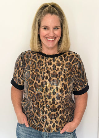 Animal print sequin shirt featuring short sleeves and black contrast trim on the neckline and sleeves.