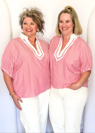 Striped seersucker top in pink and white with short sleeves, relaxed fit, and split neckline.