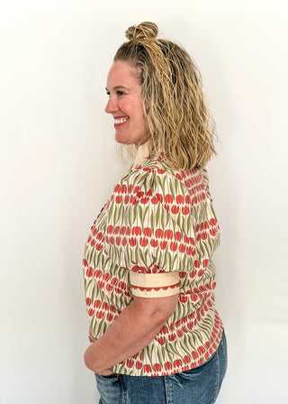 Large puff sleeve top with terracotta tulips and green leaves.  Contrast is ecru with terracotta scallop detail-short sleeve and v-neck.