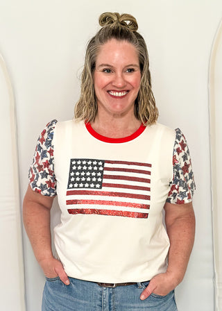 Sequin Flag with red and blue sequin star sleeves and red contrast banding on collar. 