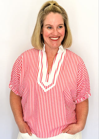 Striped seersucker top in pink and white with short sleeves, relaxed fit, and split neckline.