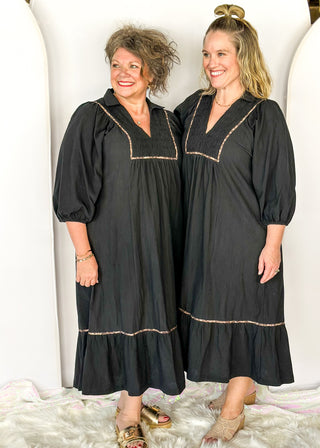 Black V-neck midi dress with leopard print detail on front and around bottom tier. 