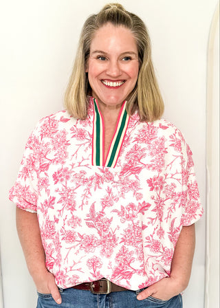 White top with pink floral pattern and v-neckline with contrast trim