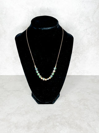 Necklace on a black mannequin bust against a white background