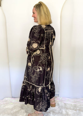 Black midi dress with cream piping and tie details on sleeves and waist.