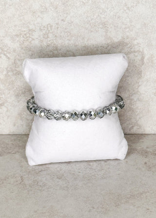 Silver beaded bracelet displayed on a stand 