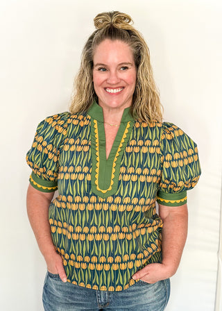 Large puff sleeve top with golden tulips and green leaves.  Contrast is green with yellow scallop detail-short sleeve and v-neck.