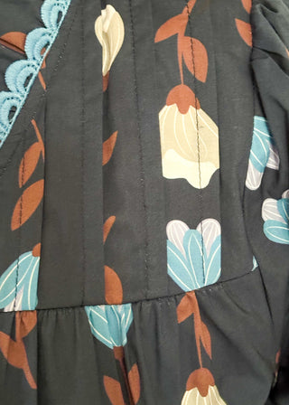 navy 3/4 length top with light blue and cream flowers and brown stems - light blue scalloped trim detail around v-neck