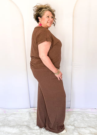 brown two-piece lounge set with relaxed short sleeve top and wide-leg drawstring pants.