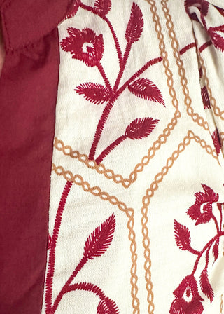 close up of neutral blouse featuring garnet florals with geometric hexagon pattern.
