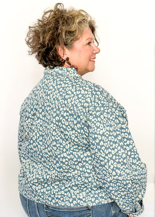 Cropped denim jacket with a blue and white floral print, long sleeves, button-front closure, and chest pockets