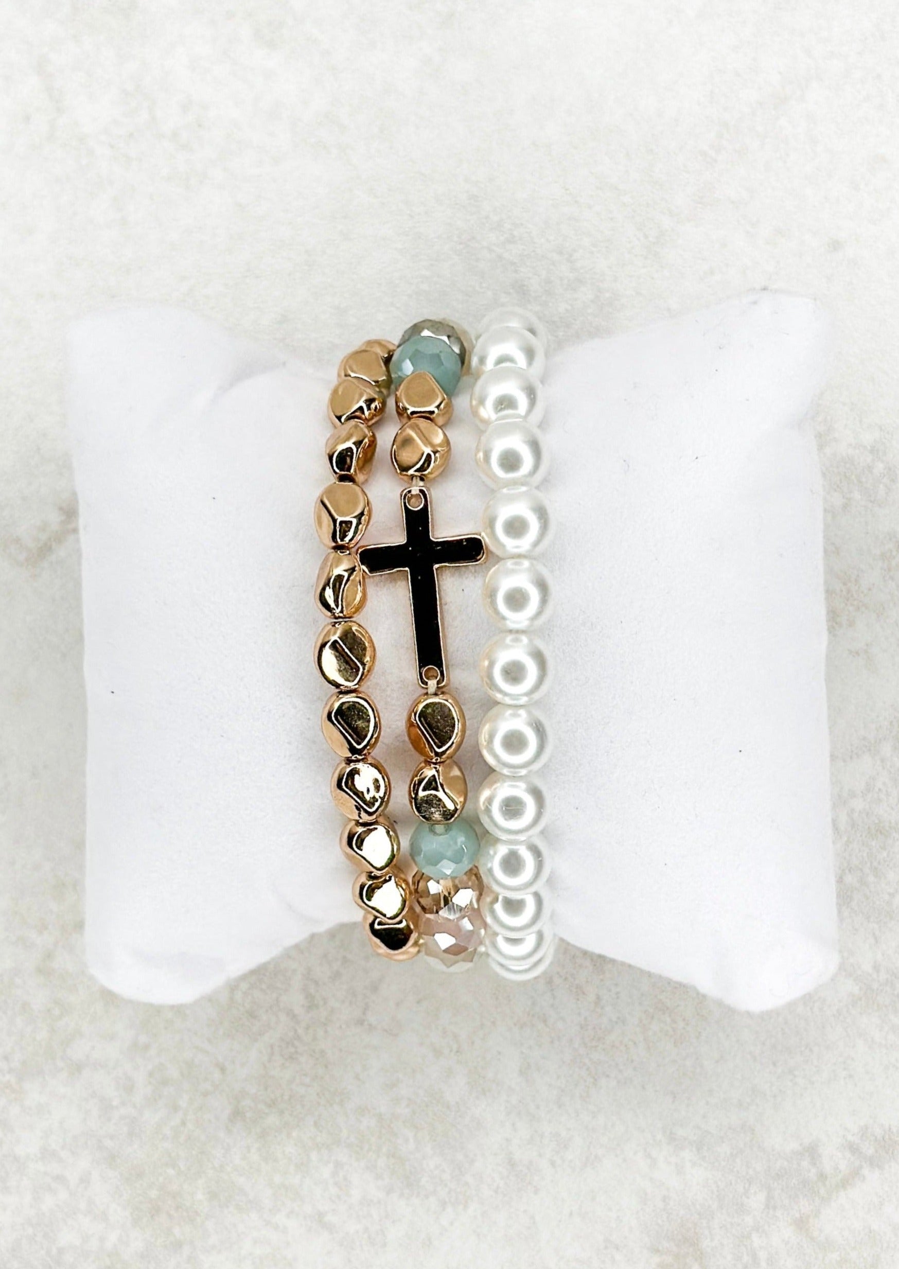 3 strand beaded stretch bracelets - one gold, one white pearl looking - one multi colored with gold and a single gold cross