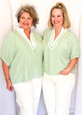 Striped seersucker top in green and white with short sleeves, relaxed fit, and split neckline.