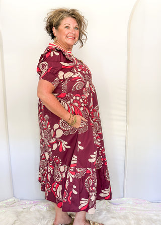 Plum floral maxi dress with short sleeves and v-neck. Collar has contrast piping in light brown and coral. 