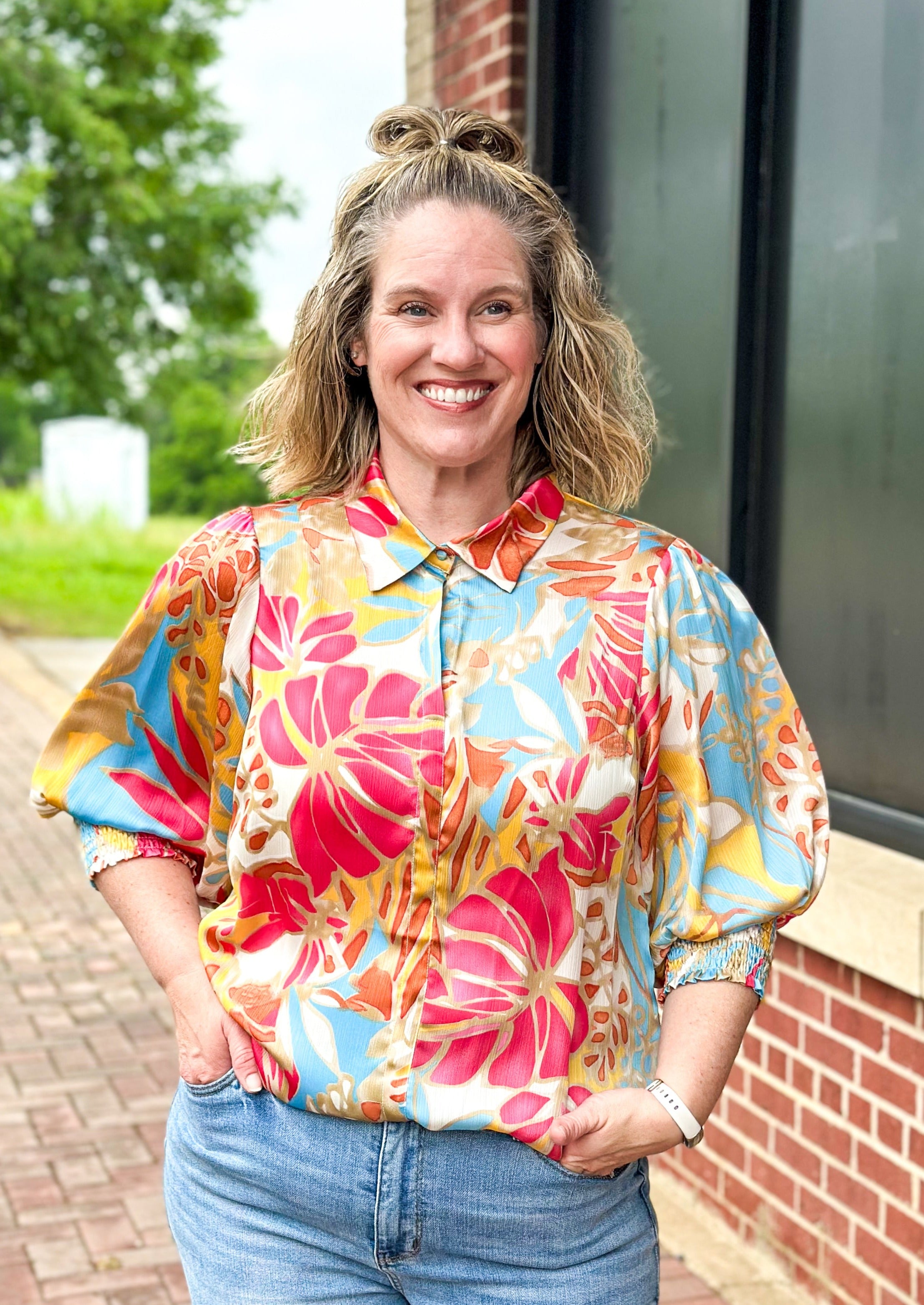 Leaf print 3/4 sleeve with v-neck, top button and collar - print is dark fuschia, gold, cream, orange and light blue - smocked cuff at edge of sleeve - crepe satin feel