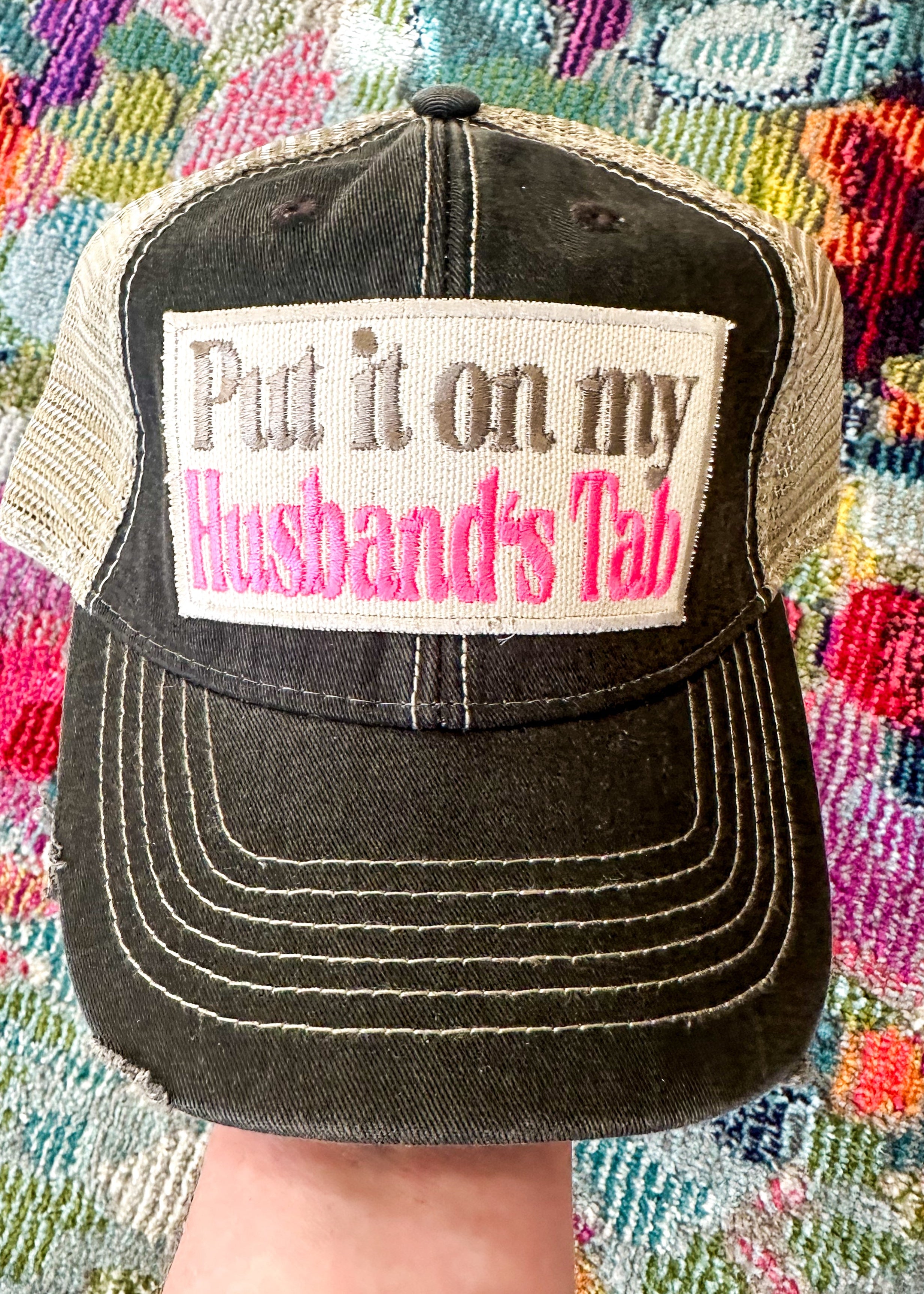 Put it on my Husband's Tab patch in khaki and hot pink. Distressed black front and khaki mesh back.

Snap back.