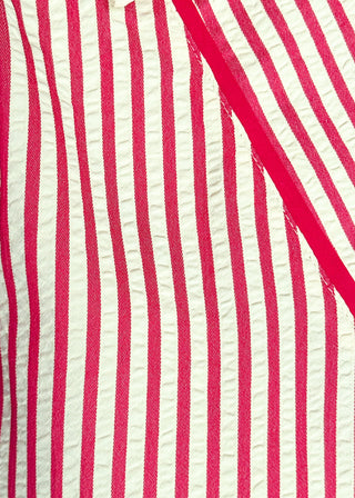 close up of raspberry and white vertical stripes on a short sleeve v neck midi dress. 