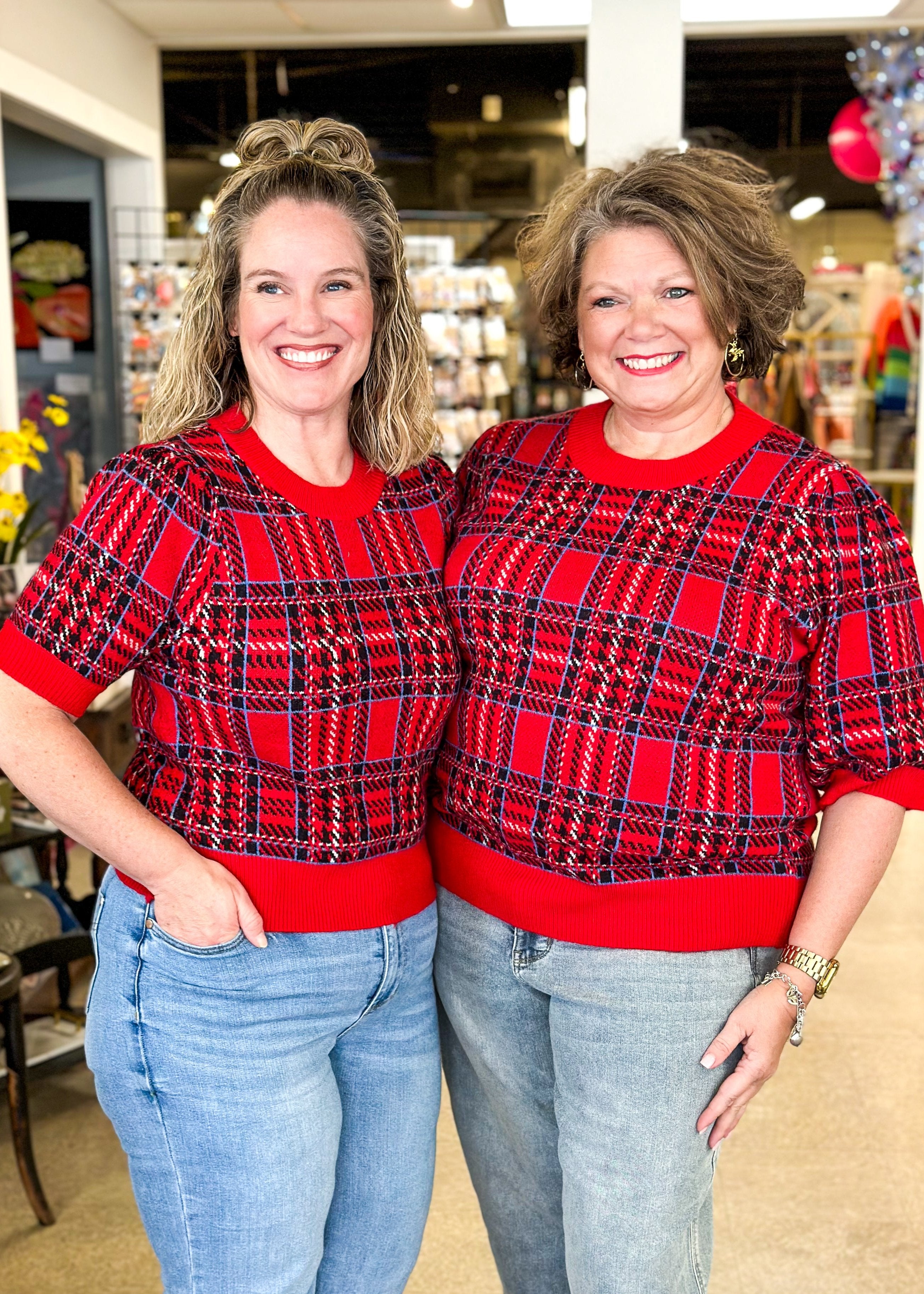 Red plaid short puff sleeve sweater with black and blue plaid and sold red bands around cuff, hem and neck