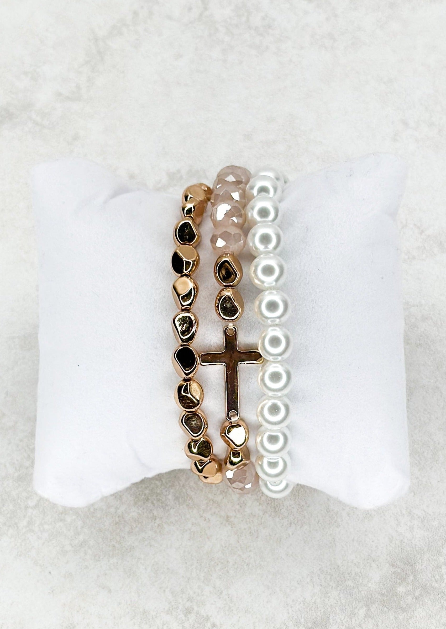 3 strand beaded stretch bracelets - one gold, one white pearl looking - one light pink colored with gold and a single gold cross