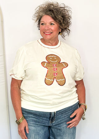 woman modeling a short sleeve puff sleeve top with fabric gingerbread man with sequins and embroidery details