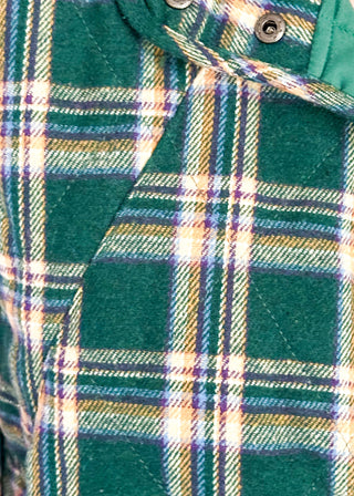 Close up of green plaid puffer vest with snap front and side pockets.