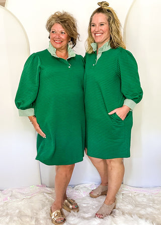 Green quilted 3/4 length sleeve dress with green and white stripe ruffle collar and matching sleeve detail.  Knee length