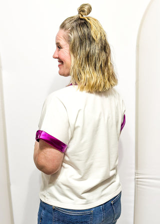 Short sleeve tee with metallic purple contrast on the sleeve and collar. Sequin Mardi Gras symbols on front. 