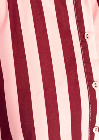 Close up of Pink/wine striped dress fabric and buttons.