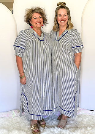 Blue and cream striped midi dress with short sleeves, split V-neckline with contrast trim, pockets, and a relaxed fit.