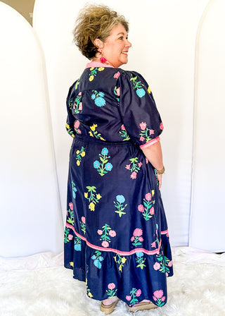 Colorful floral navy midi dress featuring pink contrast trim and a gathered waistline