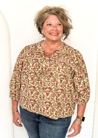 Corduroy texture with a beige background and dusty pink and maroon florals.  Multi tie closure in the front and 3/4 sleeve.