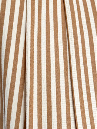 close up of sleeveless dress with vertical taupe and white stripes. v neck and smocked waist