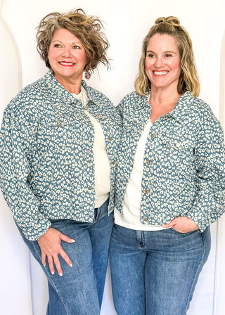 Cropped denim jacket with a blue and white floral print, long sleeves, button-front closure, and chest pockets