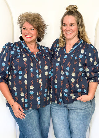 navy 3/4 length top with light blue and cream flowers and brown stems - light blue scalloped trim detail around v-neck