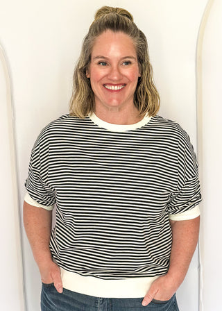 Striped knit dolman top with crew neckline and ribbed trim in black.
