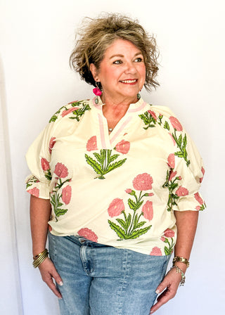3/4 smocked sleeve cream top with large pink blooms. V-neck with pink trim detail. 